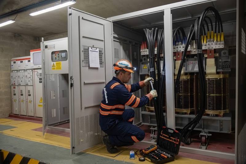 Técnico de Ingeniesys ajustando conexiones de un transformador en una subestación interior